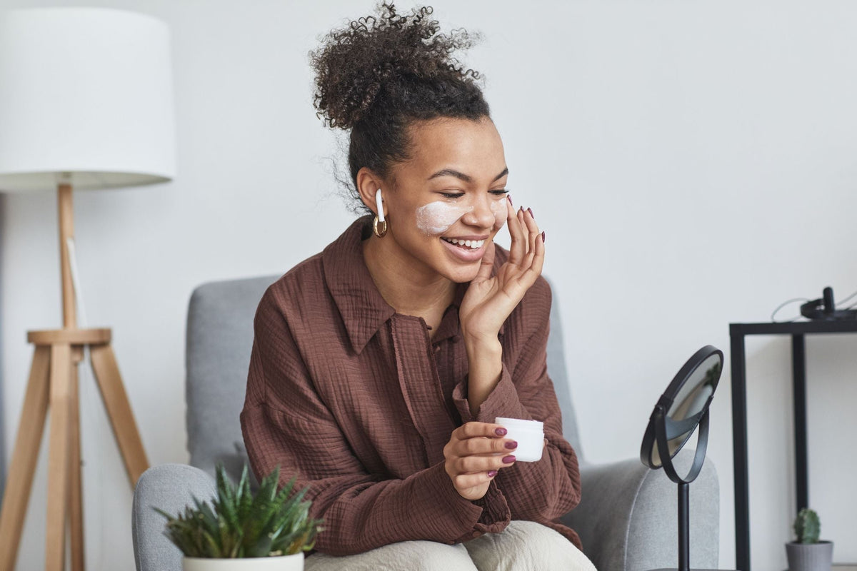 Woman applying skincare during a quiet self-care moment at home