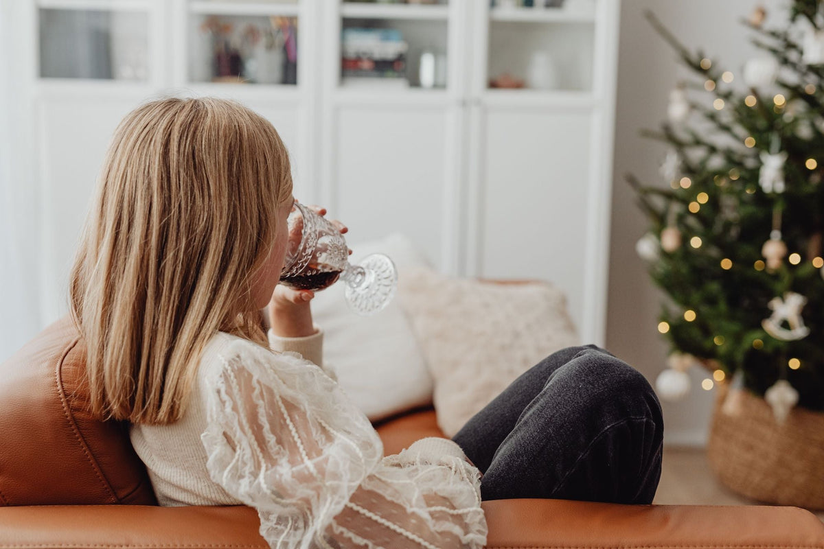 Woman relaxing by the Christmas tree during a quiet holiday moment at home