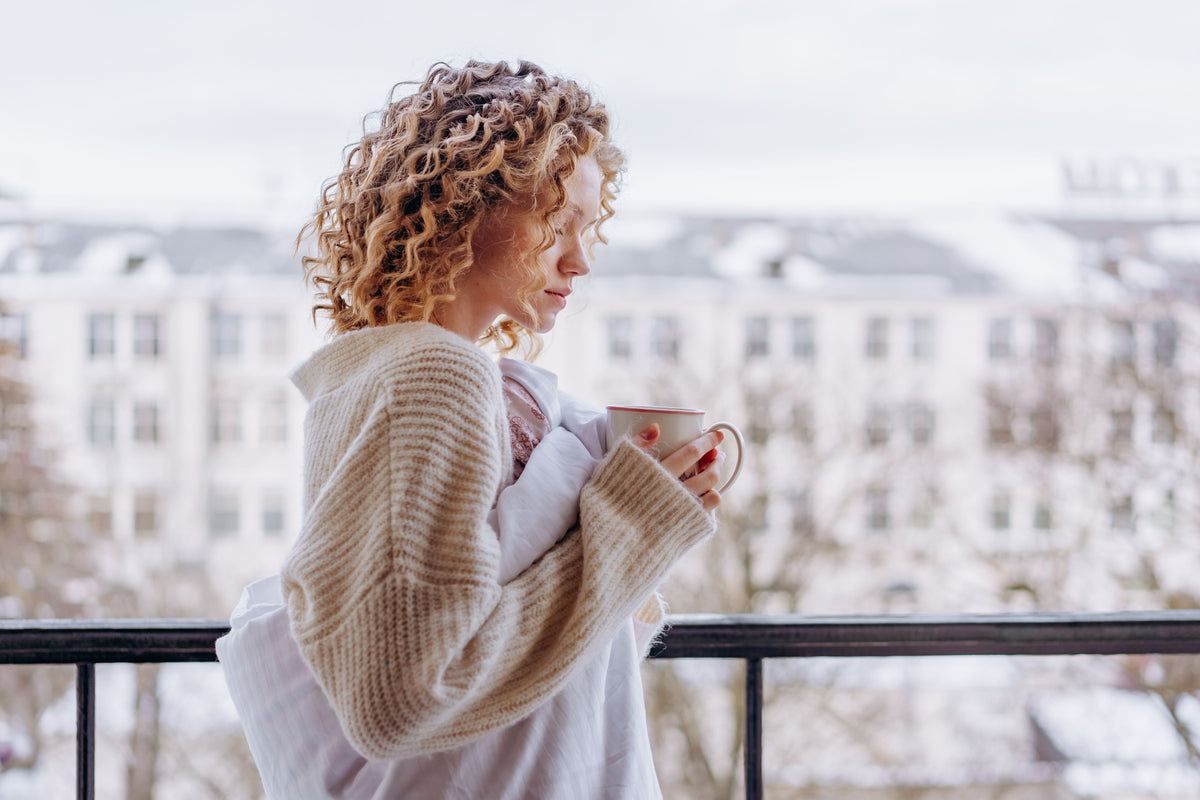 Woman enjoying a quiet moment with coffee while resetting after a difficult week