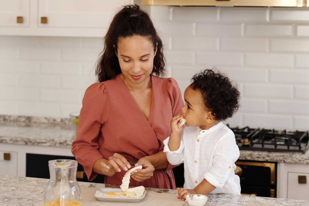 Mom preparing food with her child during a busy day at home